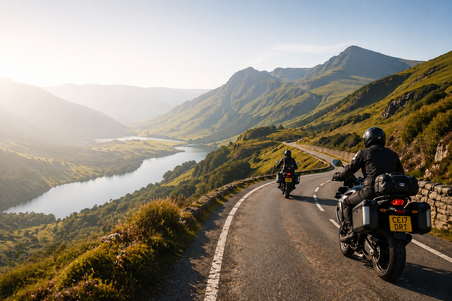 Motorcyclists riding through mountain roads beside a lake